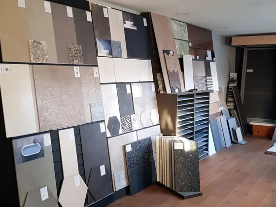 Wand met grote tegelstalen in diverse kleuren in de showroom