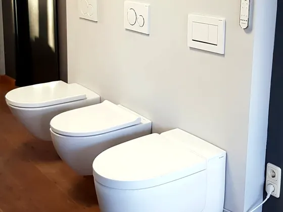 Drie witte hangtoiletten naast elkaar in de showroom